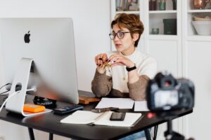 confident elegant lady in eyeglasses hosting webinar