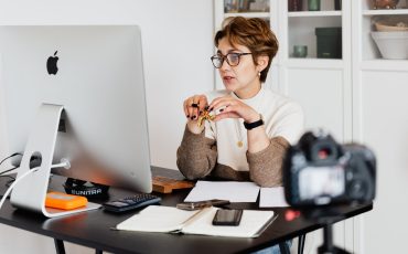 confident elegant lady in eyeglasses hosting webinar